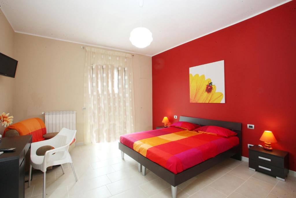 czerwona sypialnia z łóżkiem i biurkiem w obiekcie La Dimora w mieście Bari