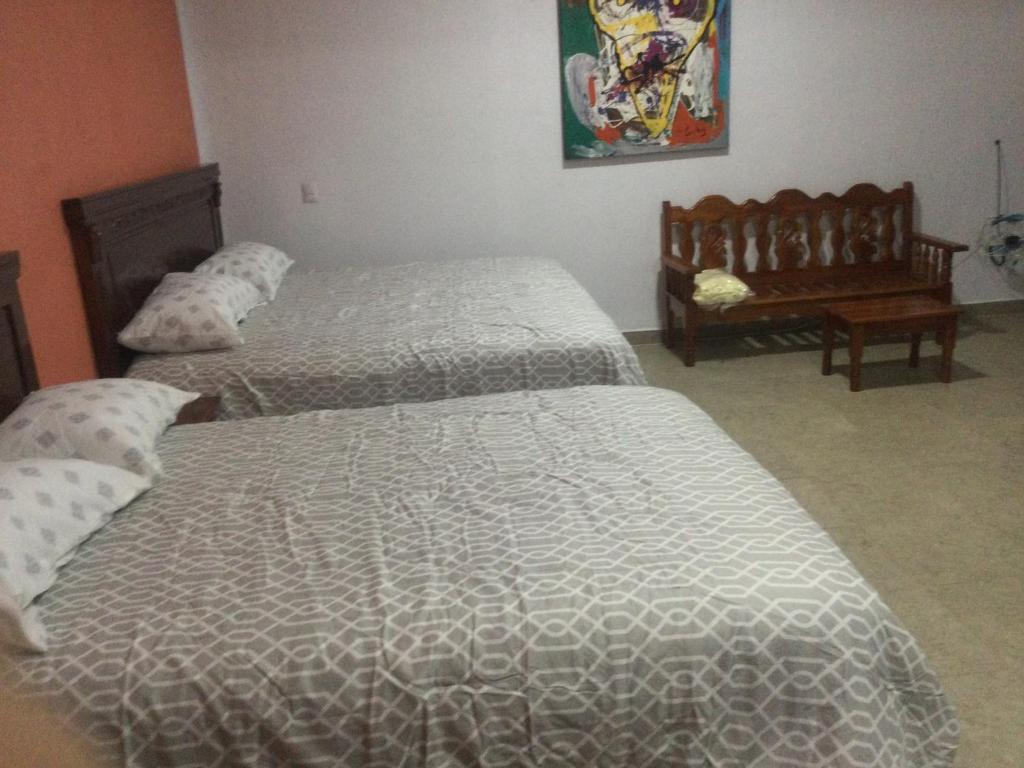 San Agustin de las JuntasにあるCasa alebrijesのベッドルーム1室(ベッド2台、テーブル付)