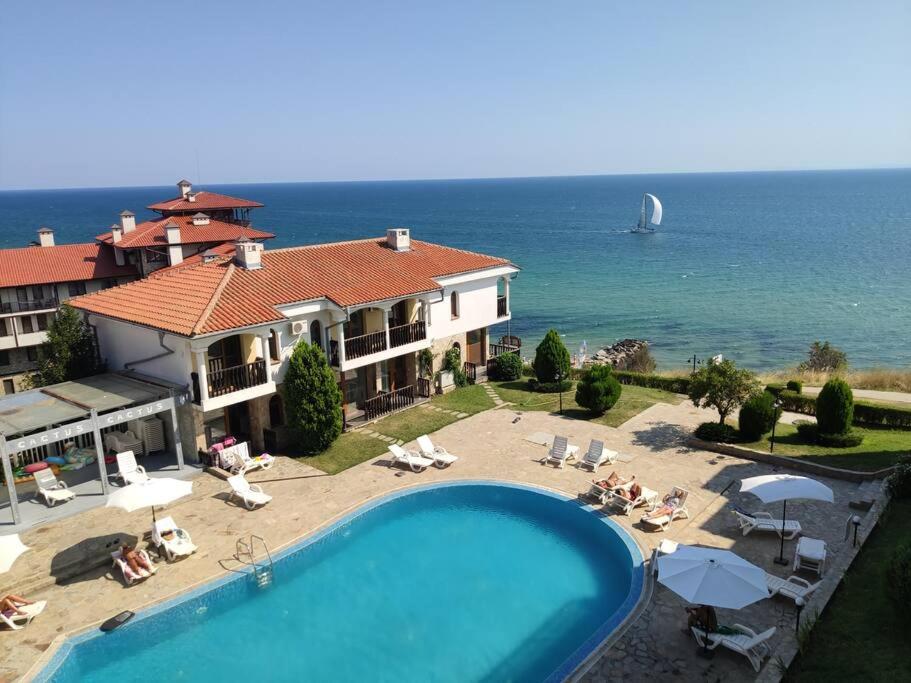 a house with a swimming pool next to the ocean at Sun Coast Apartment in Sveti Vlas