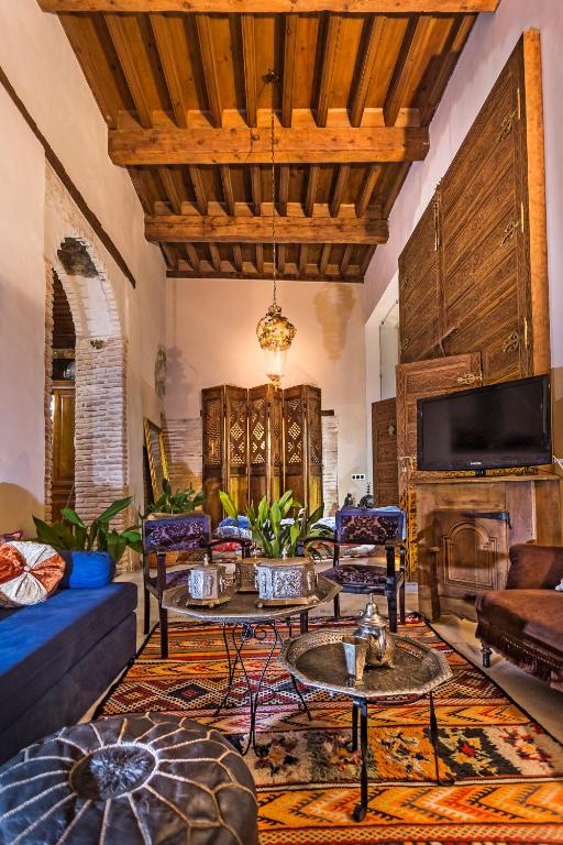 sala de estar con sofá, mesas y chimenea en Casa Palacio Rincón de la Catedral, en Toledo