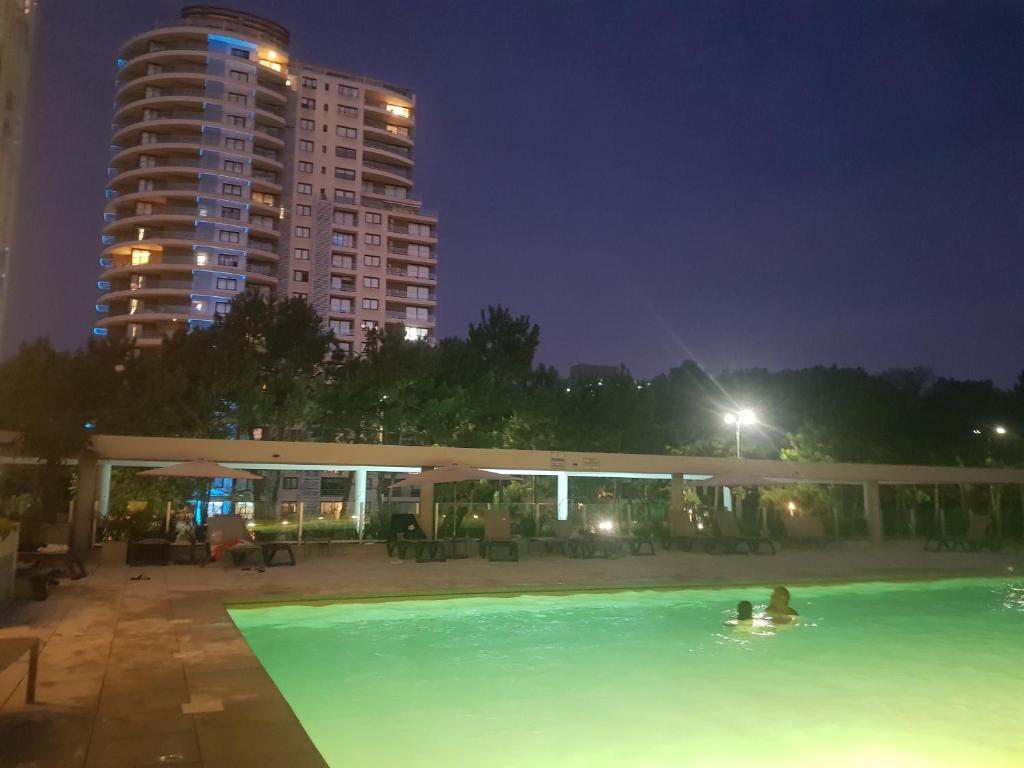 una piscina por la noche con un edificio alto en Ocean Drive Country - Punta del Este, en Punta del Este