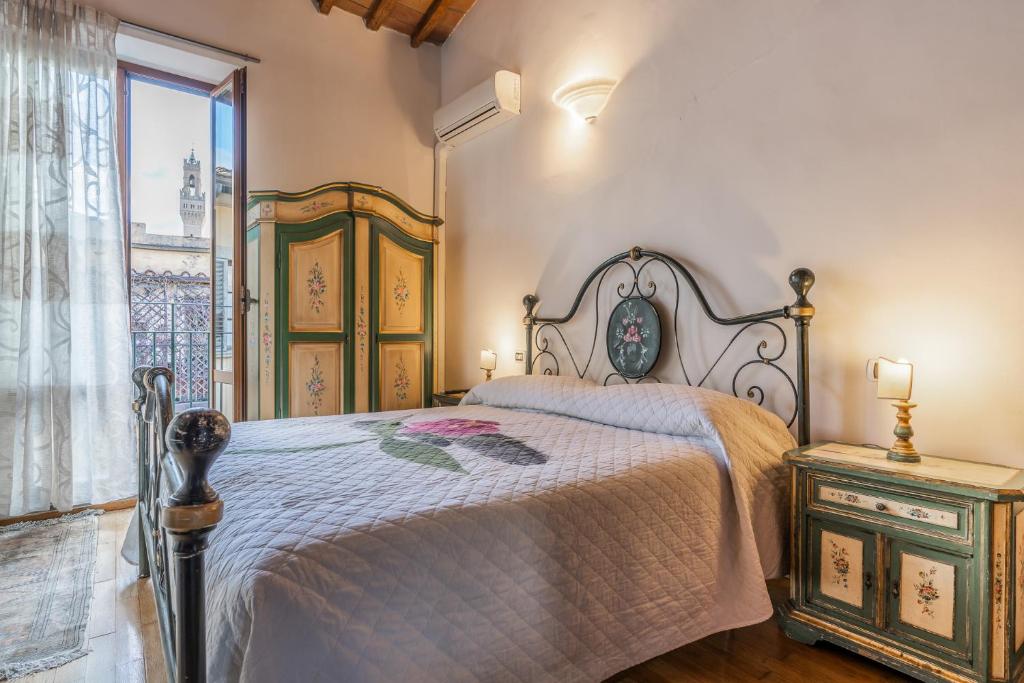 Un dormitorio con una cama grande y una ventana en Firenze Rentals Mini Suite Corso, en Florencia