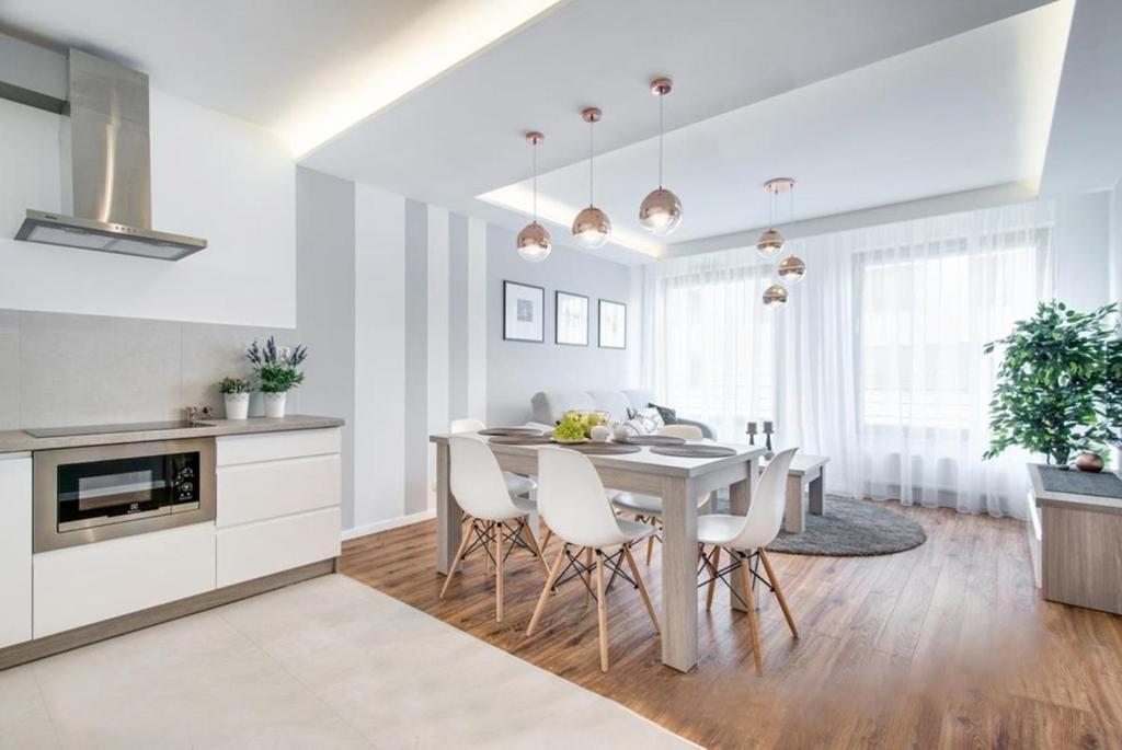 cocina y comedor con mesa y sillas en Apartment Masarska, en Cracovia