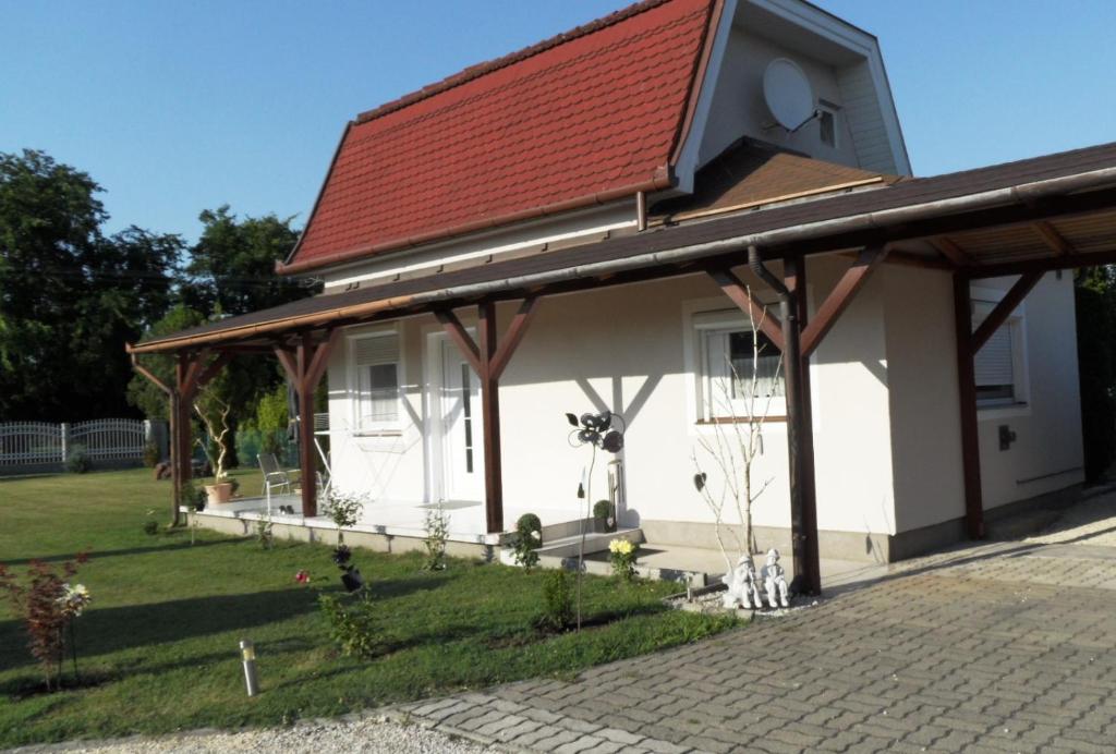 ein kleines weißes Haus mit rotem Dach in der Unterkunft Ferienhaus am Plattensee in Balatonmáriafürdő
