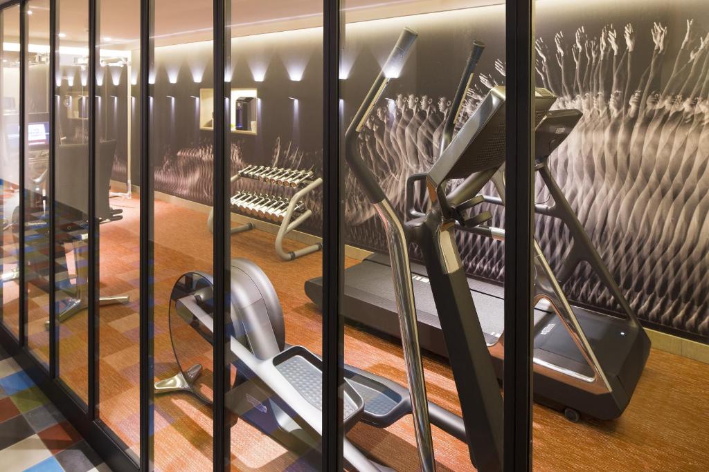 a gym with a treadmill and a bench at Hotel D - Strasbourg in Strasbourg