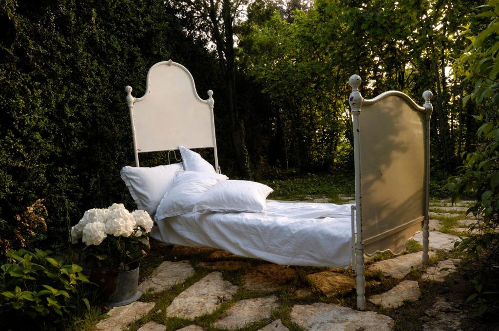 - un lit avec des draps blancs et un miroir dans l'établissement Ca'Bevilacqua Bed&Breakfast, à Bertinoro