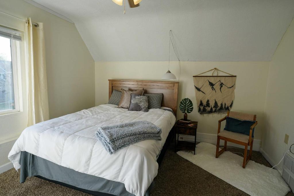 1 dormitorio con 1 cama grande y 1 silla en 2 Bedroom Apartment near NDSU and Downtown Fargo, en Fargo