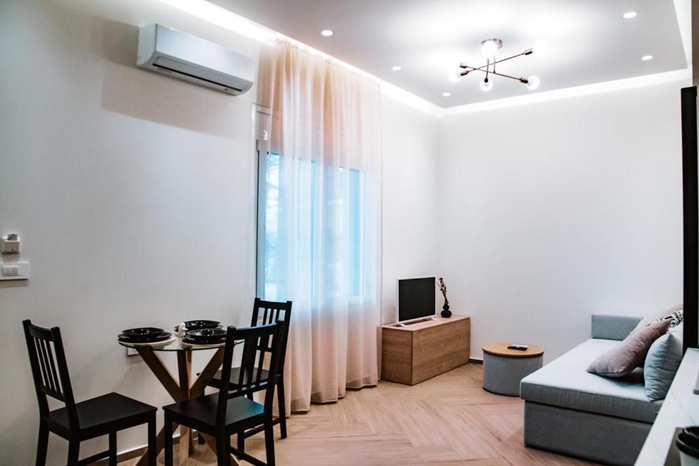 Una sala de estar con un sofá y una mesa con sillas. en Syvota Apartments Cozy, en Sivota
