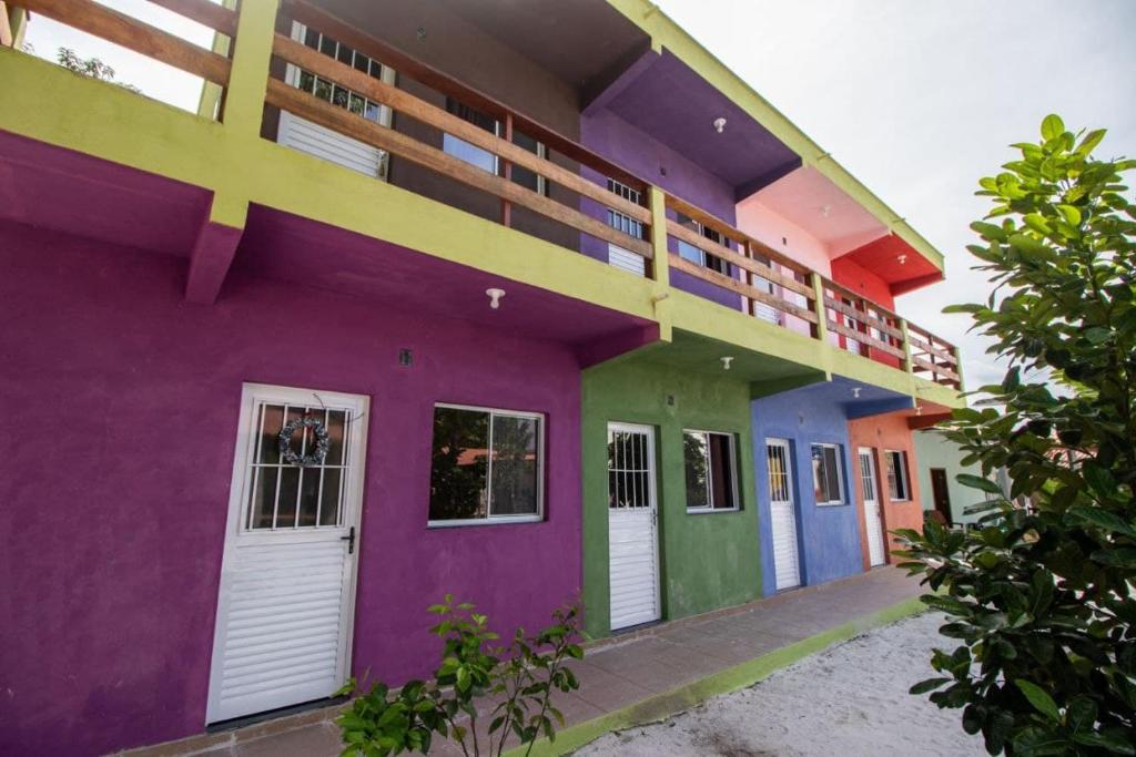 um edifício colorido com portas e janelas coloridas em Pousada Recanto do Galo em Santa Cruz Cabrália
