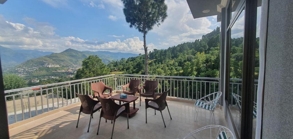 穆扎法拉巴德Srinagar Homes的阳台上的桌子和椅子，可以欣赏美景