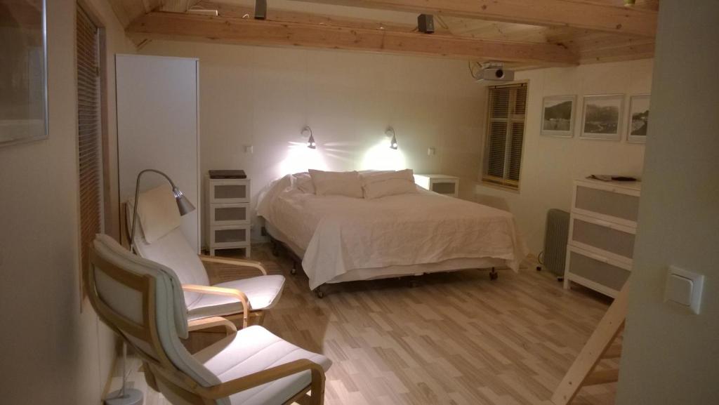 een slaapkamer met een bed en een stoel erin bij Comfortable Bungalow in Ísafjörður