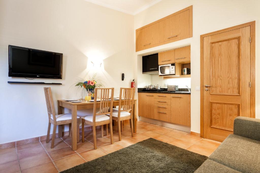 a kitchen and dining room with a table and chairs at Pestana Palm Gardens in Carvoeiro
