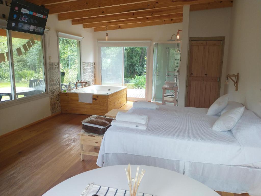 a bedroom with two beds and a bathtub and a room with a tub at Momentos del Espera in Tigre
