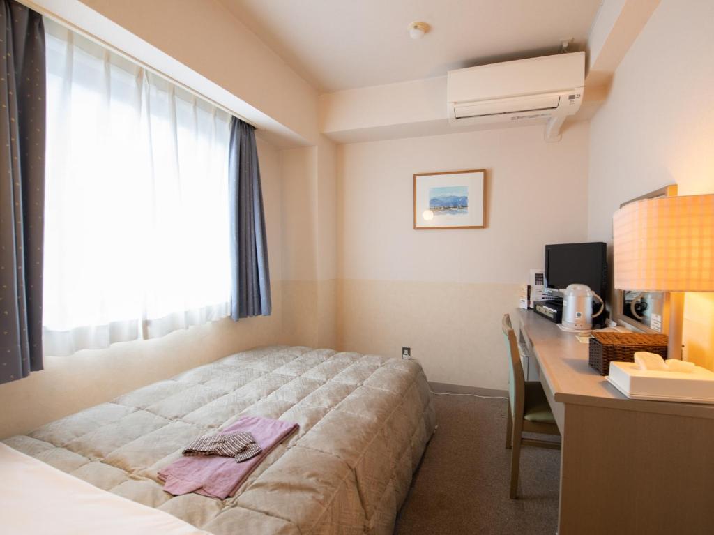 Postel nebo postele na pokoji v ubytování Hotel Iidaya