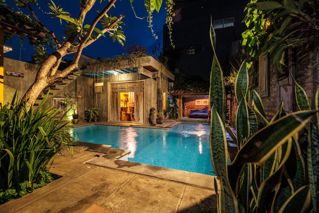 a swimming pool in a backyard at night at Nextdoor Homestay in Yogyakarta