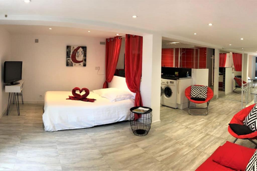 um quarto com uma cama com uma fita vermelha em Appartement 50 m2 dans une maison privative avec terrasse et jardin privée em Le Cannet