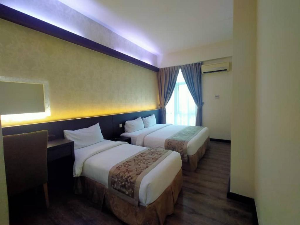 Postel nebo postele na pokoji v ubytování MidCity Hotel Melaka