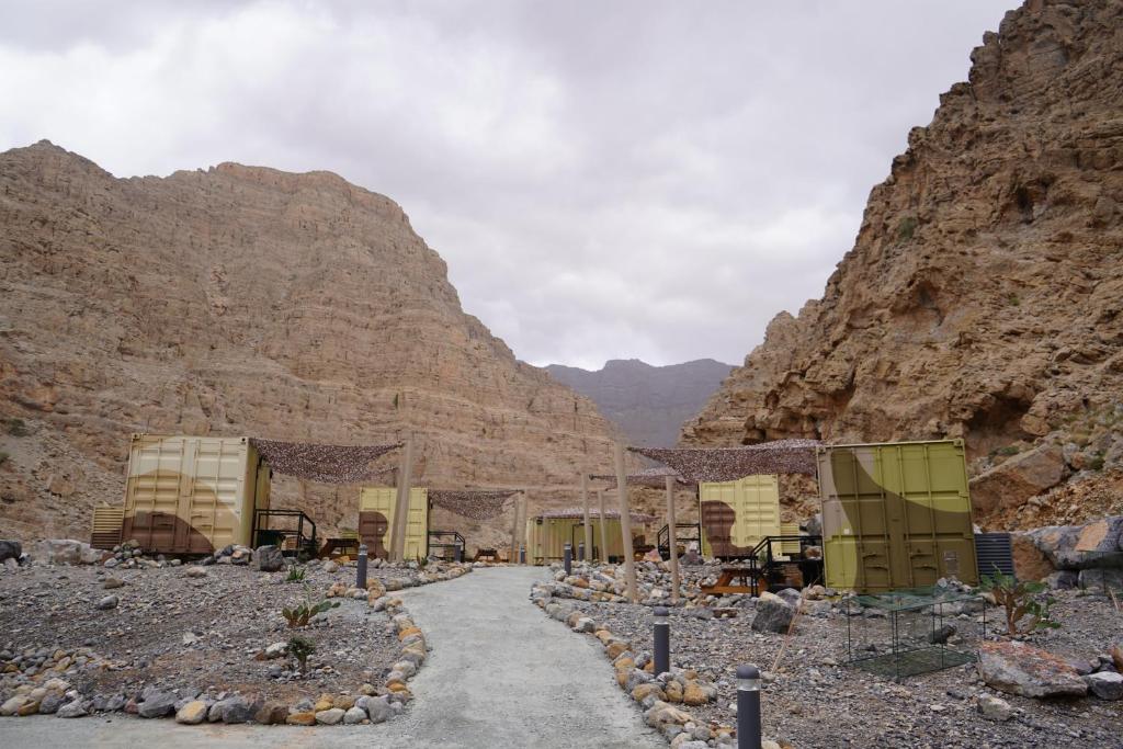 een weg in een woestijn met bergen op de achtergrond bij Bear Grylls Explorers Camp in Ras al Khaimah