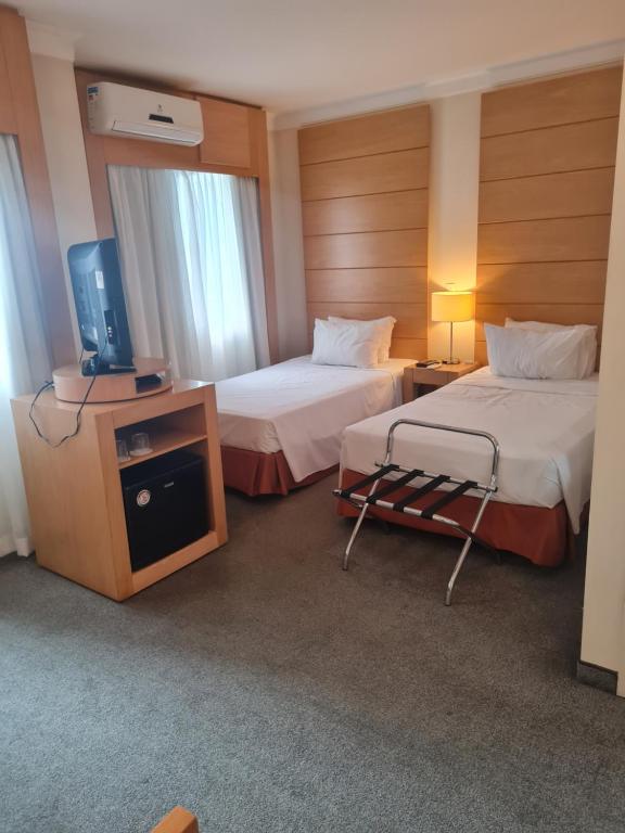 聖保羅的住宿－Nobile Congonhas，酒店客房设有两张床和电视。