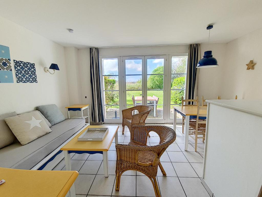 een woonkamer met een bank en een tafel bij Residence Le Bocage - Piscine chauffee in Talmont