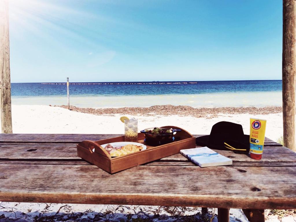 uma bandeja de comida numa mesa de piquenique na praia em On the beach-Lucky Bay em Cowell