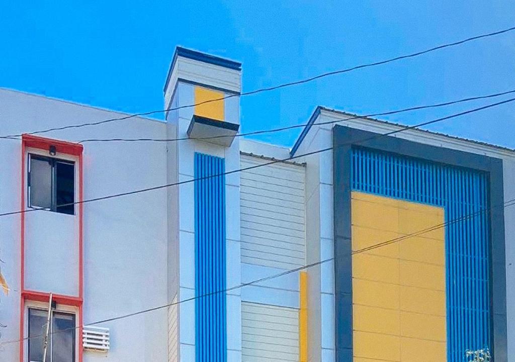 a white building with blue and yellow doors on it at RedDoorz @ Guest Hotel Passi City Iloilo in Balatocon
