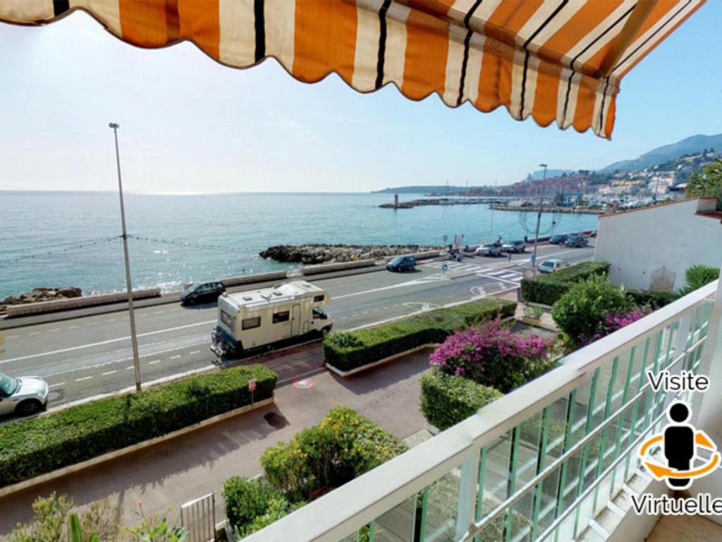 a balcony with a view of a road and the ocean at Appartement Menton, 3 pièces, 5 personnes - FR-1-196-184 in Menton