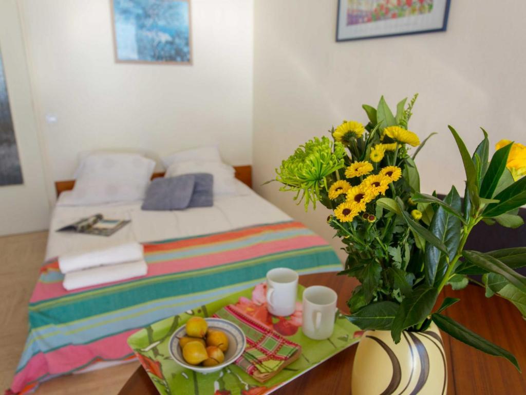 ein Schlafzimmer mit einem Bett und einem Tisch mit einer Blumenvase in der Unterkunft Appartement Menton, 2 pièces, 4 personnes - FR-1-196-222 in Menton
