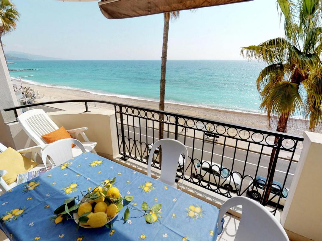 a table with fruit on a balcony overlooking the beach at Appartement Menton, 3 pièces, 6 personnes - FR-1-196-248 in Menton