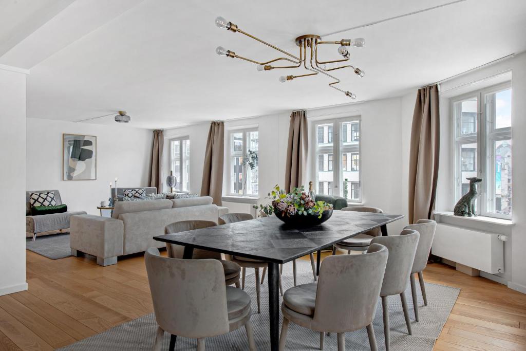 uma sala de estar com uma mesa de jantar e cadeiras em Sanders Regent - Chic Three-Bedroom Apartment Near Central Square em Copenhague