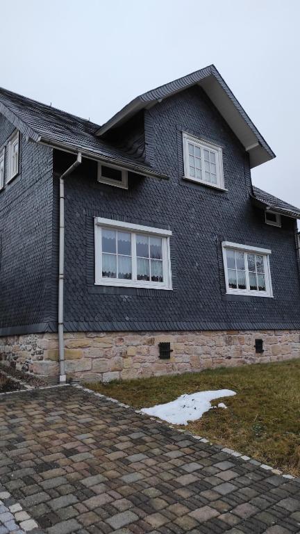 una casa di mattoni neri con finestre bianche di Zum Tischler a Ilmenau