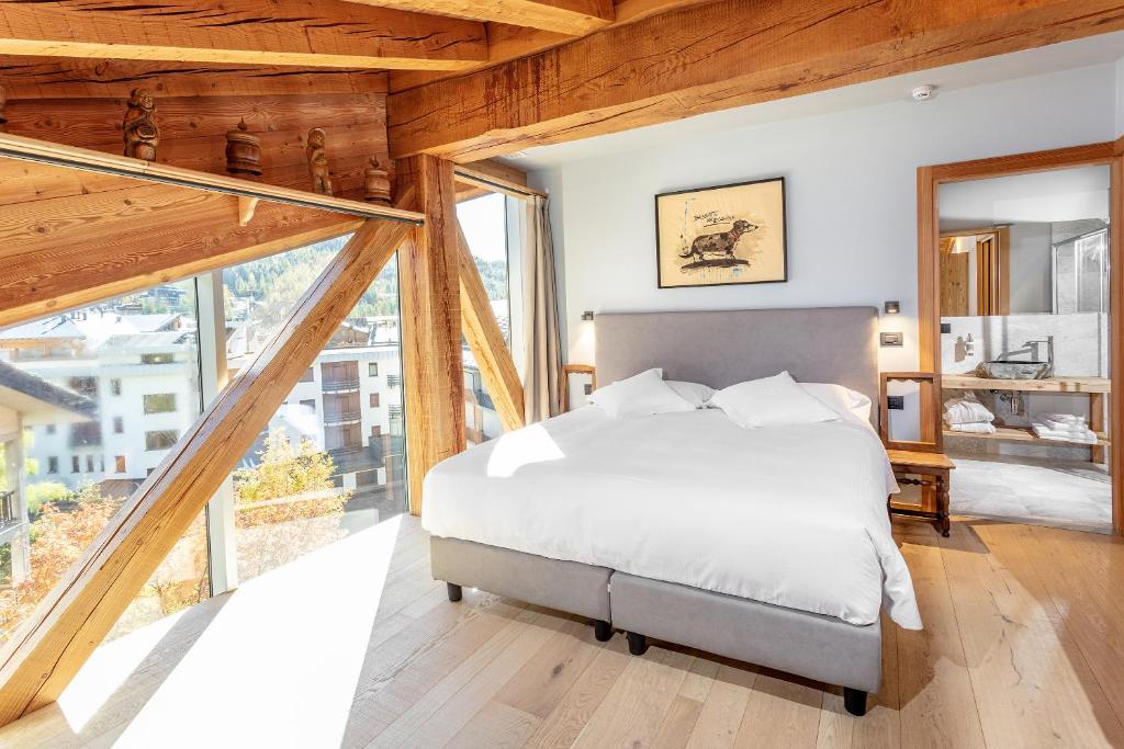 a bedroom with a bed and large windows at Aux Pieds du Roi - Suite & Spa in Breuil-Cervinia