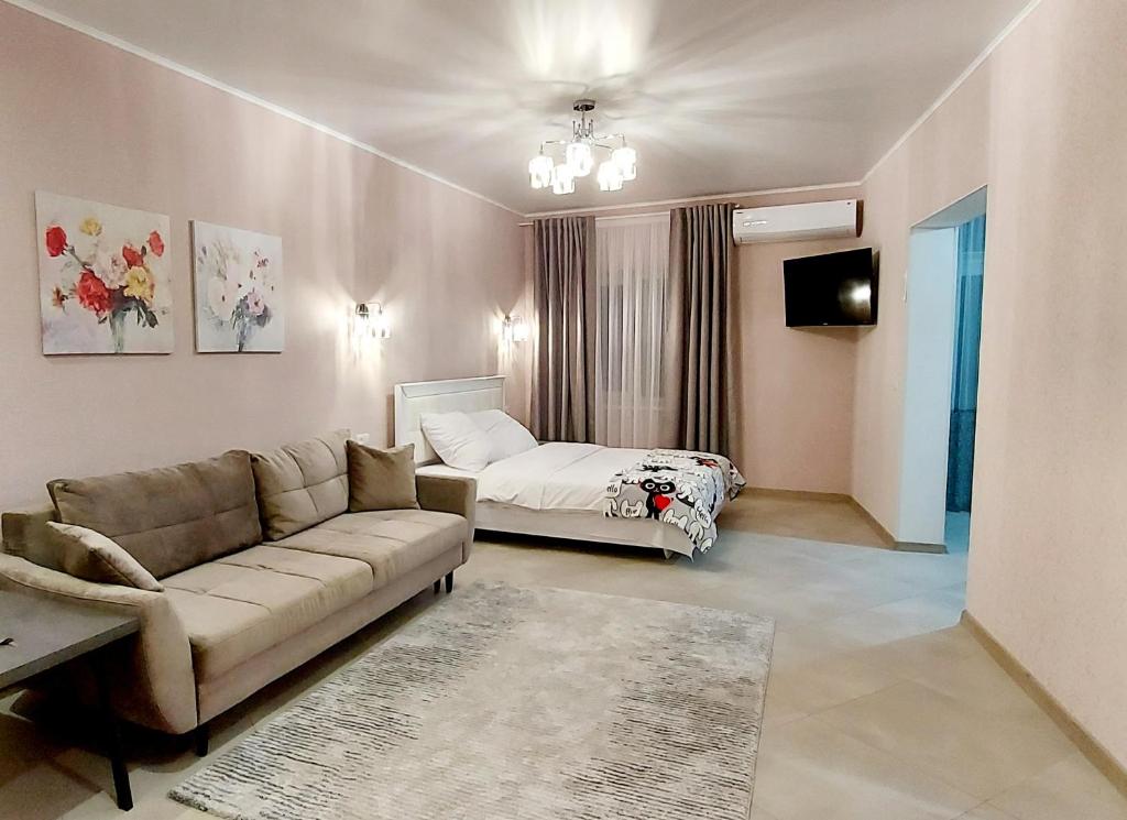 een woonkamer met een bank en een bed bij 1 кк люкс лофт студия in Nikolayev