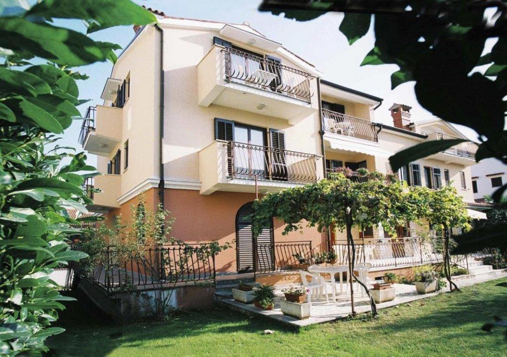 een groot gebouw met balkons en bomen ervoor bij Apartments Alice in Rovinj