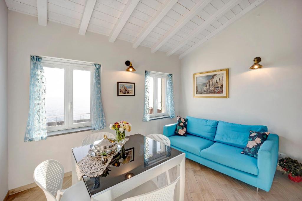 ein Wohnzimmer mit einem blauen Sofa und einem Tisch in der Unterkunft Old city apartment seaview in Bordighera