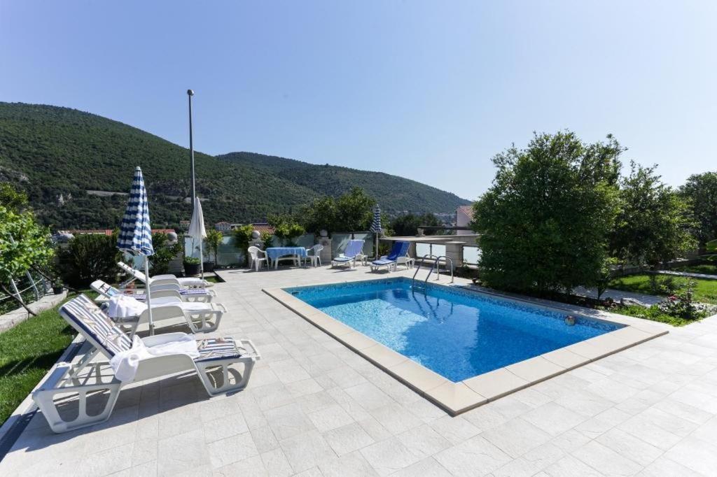 una piscina con 2 tumbonas y una piscina en Villa Celenca, en Mokošica