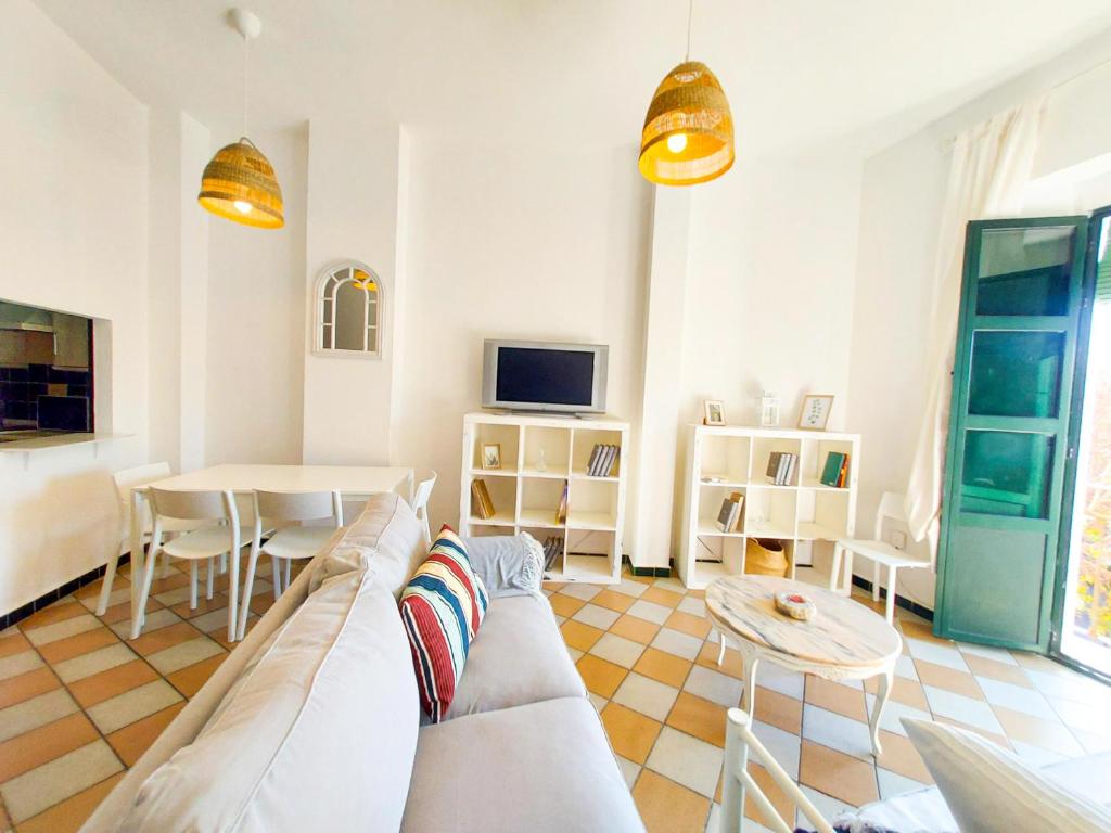 ein Wohnzimmer mit einem Sofa und einem Tisch in der Unterkunft APARTAMENTO SUITE ALAMEDA-CALATRAVA. in Sevilla