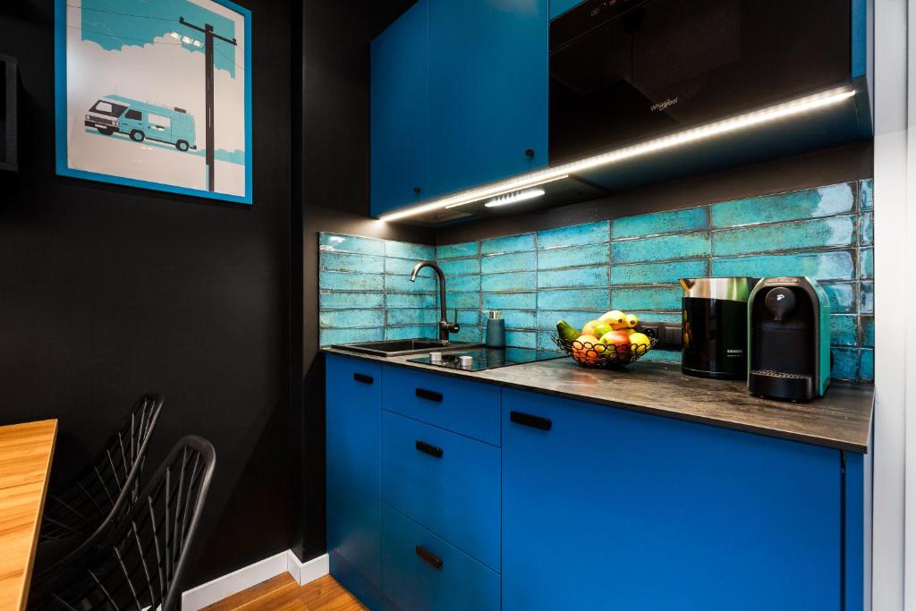 a kitchen with blue cabinets and a sink at Apartamenty Black&White in Gdynia