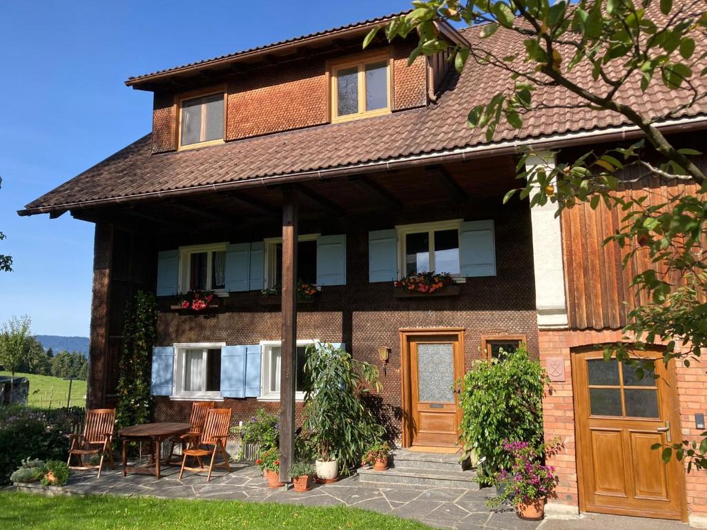 a house with a table and chairs in front of it at Waldeslust in Weiler-Simmerberg