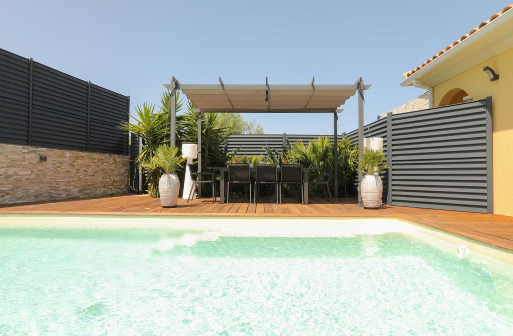 een huis met een zwembad en een patio bij Villa Marine en bord de mer... in Lumio