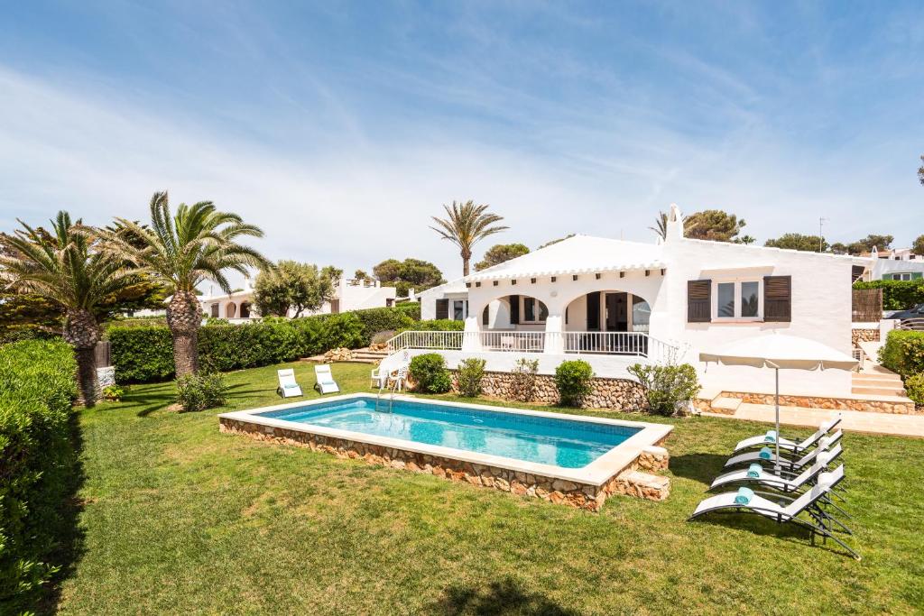 a house with a swimming pool in the yard at Villa BiniRe in Binibeca