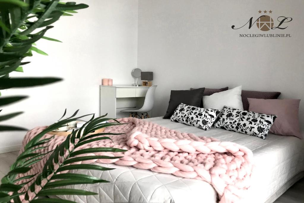 a bedroom with a bed with a pink blanket on it at Apartament Litevski Deluxe in Lublin