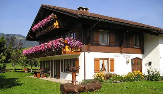 una casa con una estatua de vaca delante de ella en Haus Aigner, en Fischen