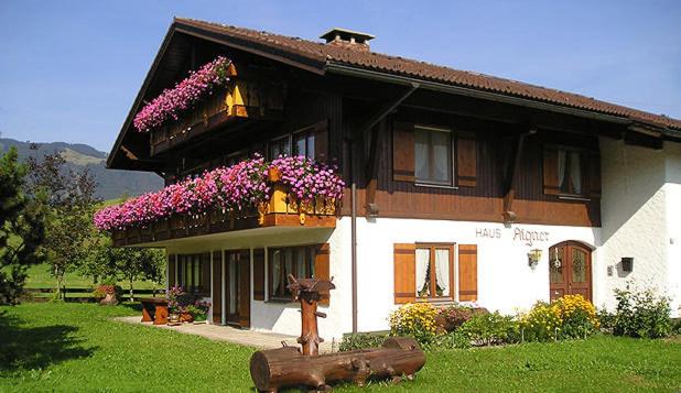 a house with a cow statue in front of it at Haus Aigner in Fischen