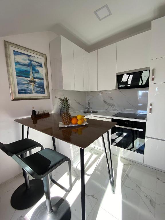 a kitchen with a table with a bowl of fruit on it at New apartman Summer in Kaštela
