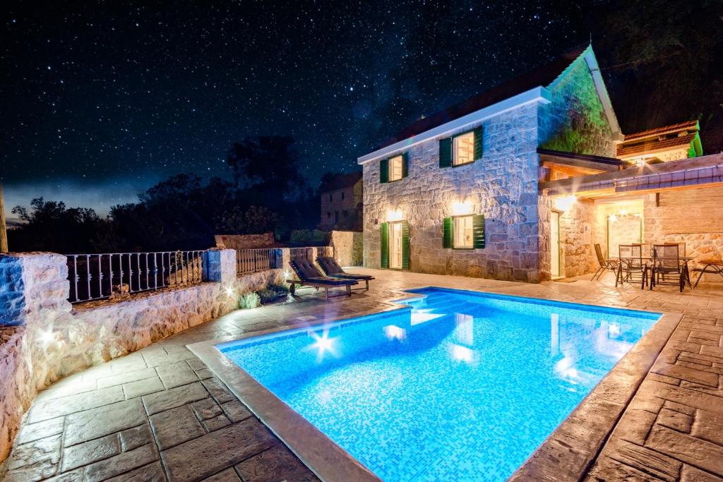ein Schwimmbad vor einem Haus in der Nacht in der Unterkunft Holiday Home Rustic in Kraljići