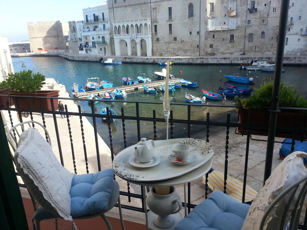 uma varanda com uma mesa e cadeiras e vista para um porto em Palazzo Venezia - Luxury holiday rooms em Monopoli