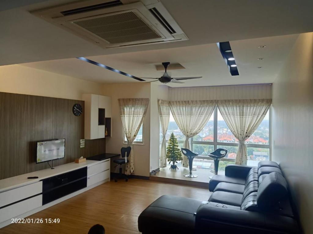 Sekinchan Paddy via Seaview Home في سيكينتشان: غرفة معيشة مع أريكة وتلفزيون