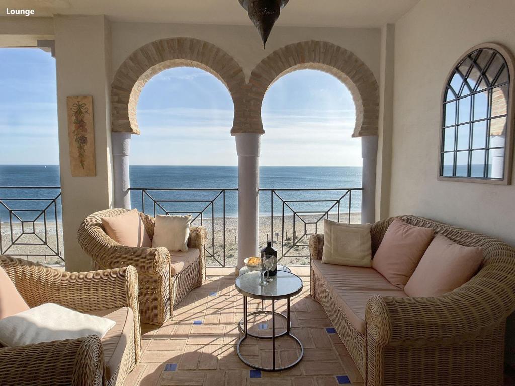 una sala de estar con 2 sofás y vistas al océano. en LA PERLA DE LA BAHIA, en Casares