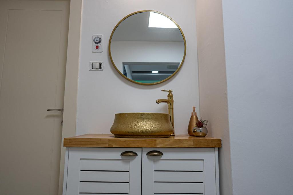 een badkamer met een wastafel en een spiegel bij סוויטות ביתרא החרמון in Mas'ada